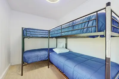 two bunk beds in a room with blue sheets at The Kingsview Lakehouse in Lake Arrowhead