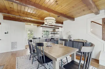 a kitchen and dining room with a wooden table and chairs at The Kingsview Lakehouse in Lake Arrowhead