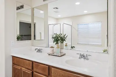 a bathroom with two sinks and a large mirror at Desert Family Oasis 4BR Near Trails Attractions in Palmdale