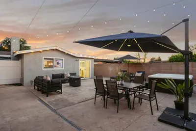 a patio with a table and chairs and an umbrella at Jedi Retreat-10mins to Disney-Hot Tub-Big Group in Anaheim