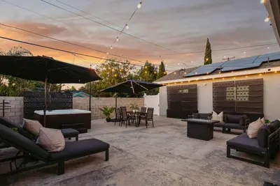 a patio with couches and tables and umbrellas at Jedi Retreat-10mins to Disney-Hot Tub-Big Group in Anaheim