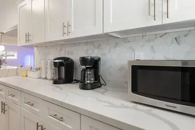 a kitchen with white cabinets and a microwave at Jedi Retreat-10mins to Disney-Hot Tub-Big Group in Anaheim