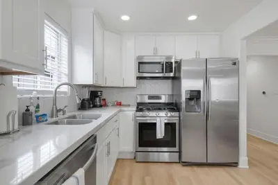 a kitchen with white cabinets and stainless steel appliances at Modern Elegance- Big Group - Games - Sleeps 10 in Los Angeles