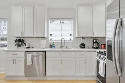 a white kitchen with white cabinets and stainless steel appliances at Modern Elegance- Big Group - Games - Sleeps 10 in Los Angeles