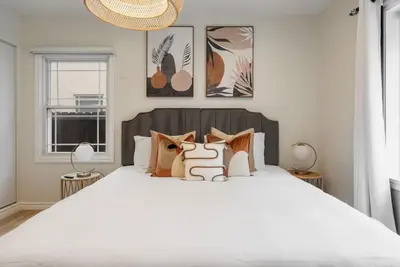 a bedroom with a large white bed with two lamps at Stunning Retro Beach Oasis, Dual Living, Pool in Long Beach
