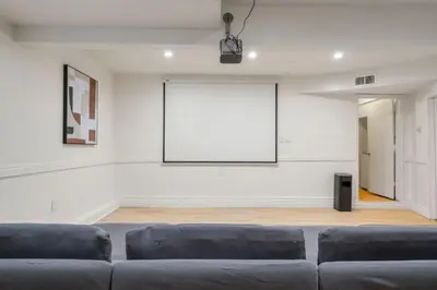 a living room with a couch and a projection screen at Designer Dream- Pool and spa- Game Room- Sleeps 10 in Los Angeles
