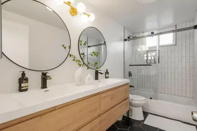 a bathroom with a sink and a tub and a mirror at Designer Dream- Pool and spa- Game Room- Sleeps 10 in Los Angeles