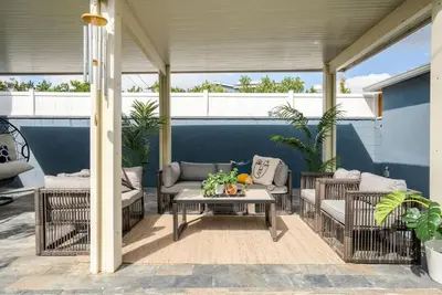 a patio with wicker furniture and a table at Refreshing Escape- Hot Tub- Games- Sleeps 10 in Long Beach