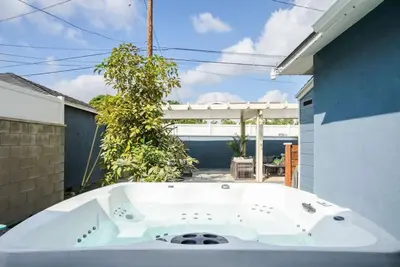 a large white bath tub sitting in a yard at Refreshing Escape- Hot Tub- Games- Sleeps 10 in Long Beach