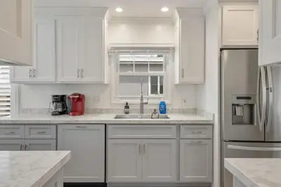 a white kitchen with a sink and a refrigerator at Refreshing Escape- Hot Tub- Games- Sleeps 10 in Long Beach