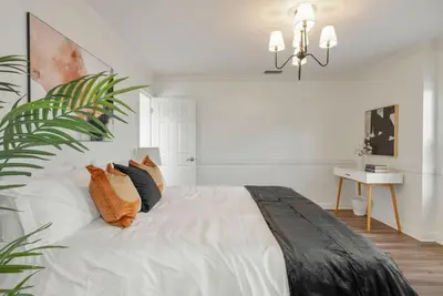 a white bedroom with a large bed with pillows at Refreshing Escape- Hot Tub- Games- Sleeps 10 in Long Beach