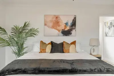 a bedroom with a large bed with many pillows at Refreshing Escape- Hot Tub- Games- Sleeps 10 in Long Beach