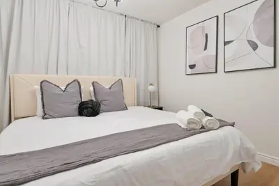a white bedroom with a large white bed with pillows at Trendy Getaway - Hot Tub - Putt Putt - Games in Long Beach