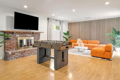 a living room with a ping pong table and a fireplace at Trendy Getaway - Hot Tub - Putt Putt - Games in Long Beach