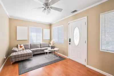 a living room with a couch and a ceiling fan at Serene Yard Porch at Signal Hill - Close to the Beach in Signal Hill