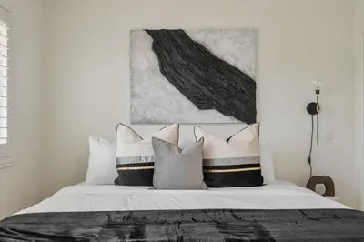 a bedroom with a large bed with black and white pillows at 2-Story Sanctuary - Spacious Hot Tub - Billiards in Los Angeles