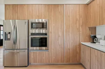 a kitchen with stainless steel appliances and wooden cabinets at ArtsDistrictDtLA-2022 BUILT WithVIEWS WD - GARAGE in Los Angeles