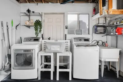 a kitchen with white appliances and a sink and a washing machine at Coastal Lagoon - Pool Heating - Games - Air Hockey in Long Beach