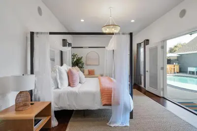 a bedroom with a bed and a swimming pool at Coastal Lagoon - Pool Heating - Games - Air Hockey in Long Beach
