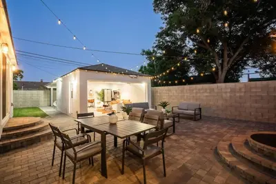 a patio with a wooden table and chairs at Luxury Hangout - Private Spa - Game Room - Arcade in Long Beach
