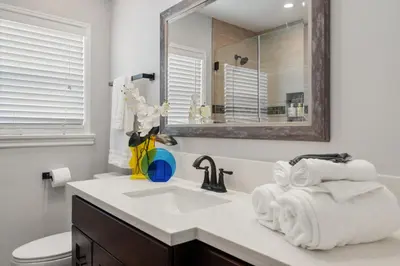 a white bathroom with a sink and a mirror at Luxury Hangout - Private Spa - Game Room - Arcade in Long Beach