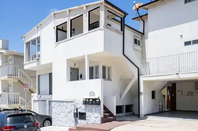 a white house with a car parked in front of it at Gorgeous Beachside Bliss Ocean View Walk2Strand in Manhattan Beach