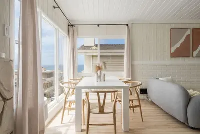 a white dining room with a table and a couch at Gorgeous Beachside Bliss Ocean View Walk2Strand in Manhattan Beach