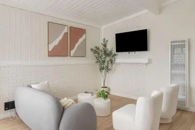 a white living room with white chairs and a flat screen tv at Gorgeous Beachside Bliss Ocean View Walk2Strand in Manhattan Beach
