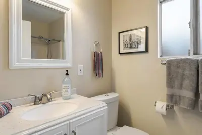 a bathroom with a sink and a toilet and a mirror at Surfers Dreams - 5min Drive to Beach with PoolTable in Long Beach