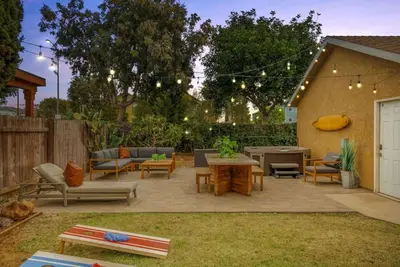 a patio with a table and chairs and a ping at Surfers Dreams - 5min Drive to Beach with PoolTable in Long Beach