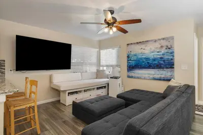 a living room with a couch and a flat screen tv at Surfers Dreams - 5min Drive to Beach with PoolTable in Long Beach