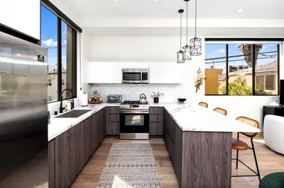 a kitchen with wooden cabinets and a large white counter top at Trendy Chic in Los Angeles