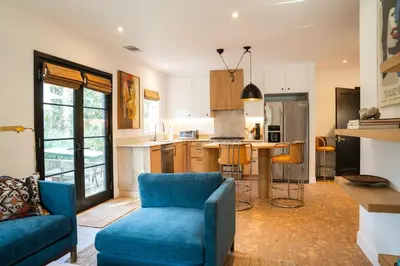 a living room with a blue couch and a kitchen at Spanish-style garden Bungalow in Burbank