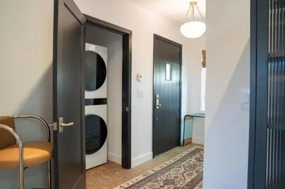 a hallway with black doors and a chair at Spanish-style garden Bungalow in Burbank