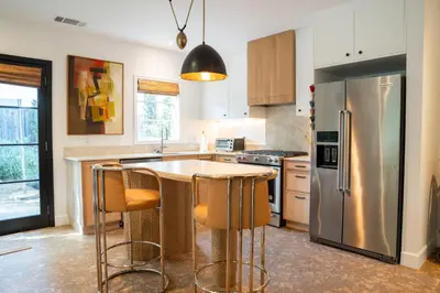 a kitchen with a stainless steel refrigerator and a table at Spanish-style garden Bungalow in Burbank