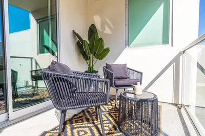 a porch with three chairs and a table and a plant at 3BR Apartment Near Santa Monica Pier in Los Angeles