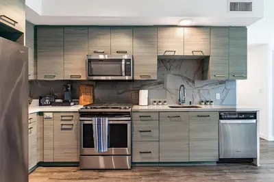 a kitchen with stainless steel appliances and wooden cabinets at 3BR Apartment Near Santa Monica Pier in Los Angeles