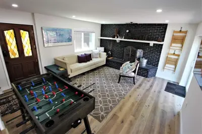 a living room with a pool table in front of a fireplace at The Train Getaway Big Bear Lake in Big Bear Lake
