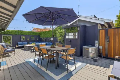 a patio with a table and chairs and an umbrella at Historic Heart of Hollywood *Newly Renovated * in Los Angeles