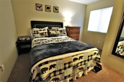 a bedroom with a bed with a blanket and a window at Summit Ski Shack in Big Bear Lake