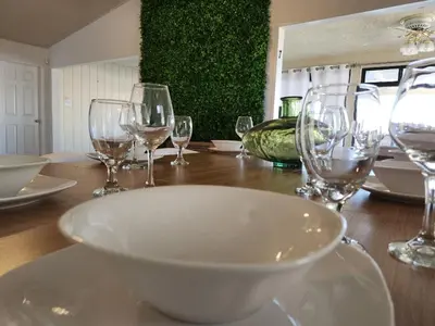 a table with wine glasses and a bowl on it at Minimalist Lake House in Helendale