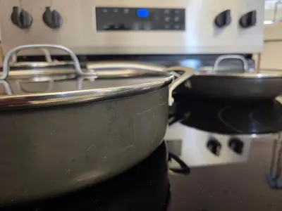 two pans sitting on top of a stove at Minimalist Lake House in Helendale
