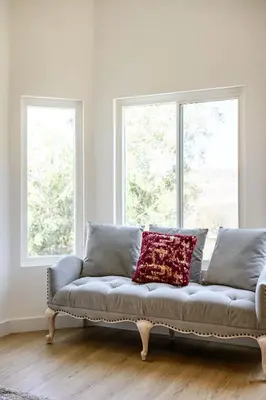 a couch in a living room with two windows at Luxe Spacious Home Near Parks Fully Equipped in Riverside