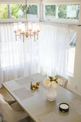 a dining room table with a vase of flowers on it at Luxe Spacious Home Near Parks Fully Equipped in Riverside