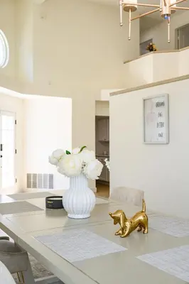 a dining room table with a vase and a gold dog statue at Luxe Spacious Home Near Parks Fully Equipped in Riverside