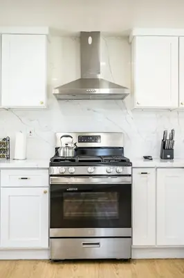 a kitchen with a stainless steel stove and white cabinets at Luxe Spacious Home Near Parks Fully Equipped in Riverside