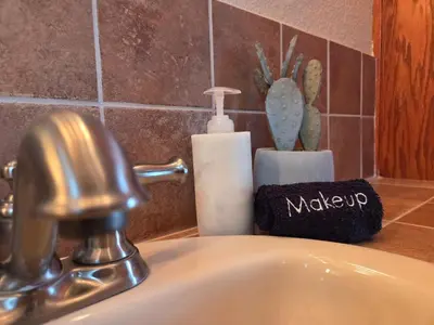 a bathroom sink with a faucet and a bottle of soap at Zen Den Studio in Apple Valley