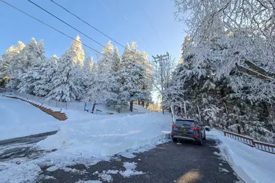 a truck parked on a snowy road with snow covered trees at Stunning Deck Views Cozy Running Springs Cabin in Running Springs