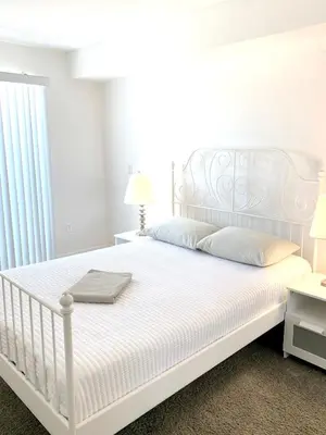 a bedroom with a white bed with white sheets and pillows at Western Melrose in Los Angeles