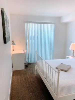 a white bedroom with a crib and a large window at Western Melrose in Los Angeles